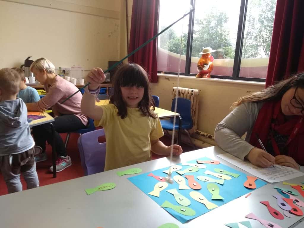 Photo of child playing with paper fish