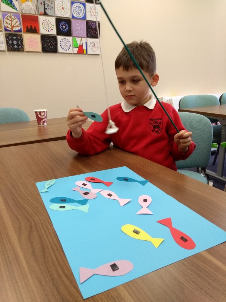 Photo of child playing with paper fish