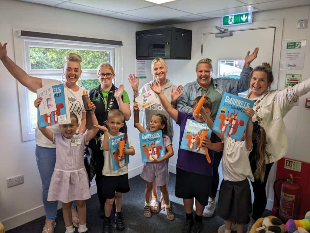 Children and parents holding story books and craft