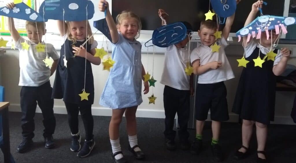 Children posing with craft
