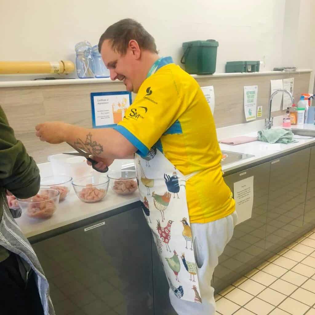 Man in apron preparing chicken